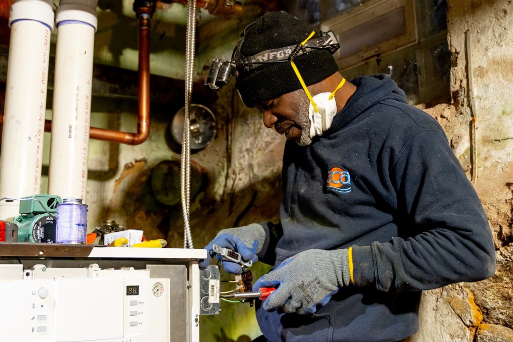 ECA employee fixing a heater.